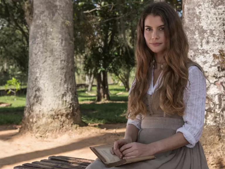 Como Lívia, Alinne Moraes constrói uma mocinha clássica com precisão rara: leve no gesto, firme na emoção e completamente alinhada ao texto. Cada olhar sustenta o romantismo da personagem sem perder densidade dramática. (Foto: Fábio Rocha/Gshow)