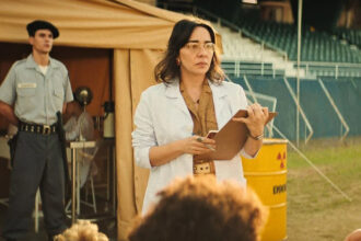Clarissa Kiste constrói uma Dra. Paula marcada pela contenção e pela humanidade em EmergenCia Radioativa, da Netflix. Em meio ao caos do desastre, sua atuação encontra força justamente no silêncio, no olhar e na responsabilidade de quem precisa agir sem espalhar o pânico. Foto: Divulgação/Netflix