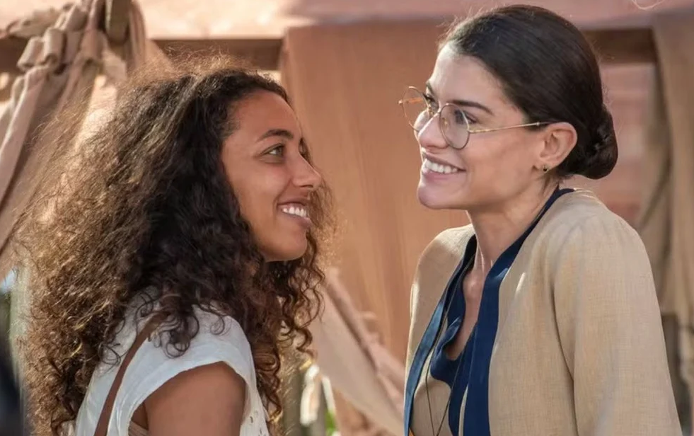 George Moura e Sergio Goldenberg permitiram que esse amor nascesse da convivência, crescesse na cumplicidade e amadurecesse ao longo da narrativa. Alinne Moraes e Alice Carvalho transformaram essa trajetória em uma das histórias mais bonitas e importantes de Guerreiros do Sol.
Representatividade também é ter direito a uma grande história de amor.
Foto: Estevam Avellar/Globo